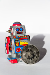 Wall Mural - vintage tin toy robot with bitcoin coin, cryptocurrency mining and investing concept