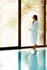 Wall Mural - Pretty young woman relaxing by swimming pool