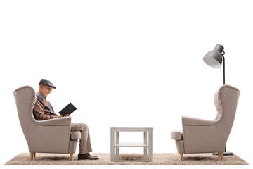 Sticker - Mature man sitting in an armchair and reading a book