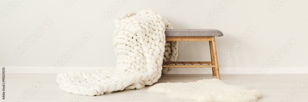 White knit blanket on stool - obrazy, fototapety, plakaty 