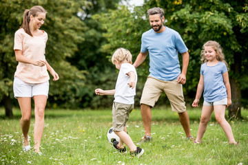 Wall Mural - Familie und Kinder spielen Fußball