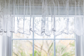 Poster - Closeup of small short lace white window curtains blinds in bright room interior indoors with pattern design decoration