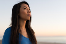 Young Asian Woman Looking At Sunset Sky