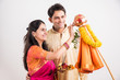 portrait of happy indian couple standing with puja or pooja thali doing gudi padwa or gudhi padwa poojan, asian couple and gudi padwa celebration, hindu new year celebration, isolated on yellow