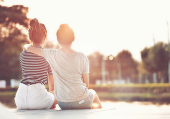 two women friends resting in the garden, watching the sunshine together happily.