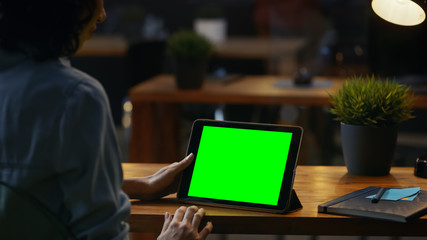 Aufkleber - Young Woman Sits at Her Wooden Desk Uses Tablet Computer with Mock-up Green Screen, She Uses Various Swipe and Touch Gestures.