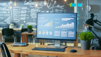 Poster - Personal Computer with Mobile Application Design Showing on the Monitor Stands on the Office Desk, In the Background Man Working in the Daytime Office Environment.