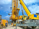 Fototapeta Miasto - Installation of technological equipment on the construction site, using a crawler and a wheeled crane