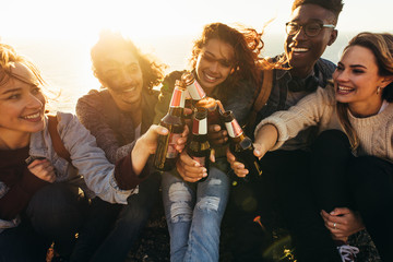 Wall Mural - Multi-ethnic group of people toasting beers outdoors