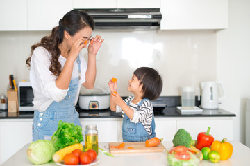 Mother with her daughter in the kitchen cooking together