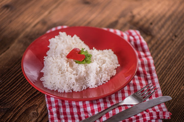 cooked riced in a shape of heart on a red plate 