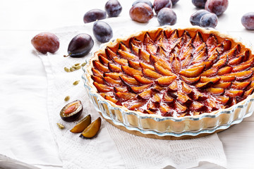 Homemade plum pie. Fruit tart on white table.