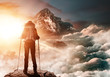 Bergsteigerin steht auf Gipfel und genießt Sonnenaufgang