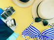 blue bikini girl summer cloth , camera , lense and accessories concept with yellow background and beach hat