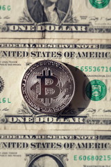 Wall Mural - silver bitcoin coin lying on united states dollars, cryptocurrency concept