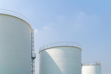 Large white water tank with blue sky.