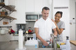 © Jasper Cole/Blend Images - Woman watching man washing baby bottle