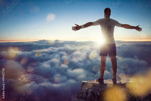 Mann über den Wolken breitet Arme aus Fototapeta