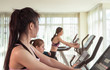 Woman in fitness is looking at slimmer thinner woman working out