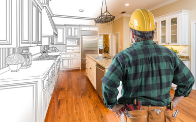 Male Contractor with Hard Hat and Tool Belt Looking At Custom Kitchen Drawing Photo Combination On White.