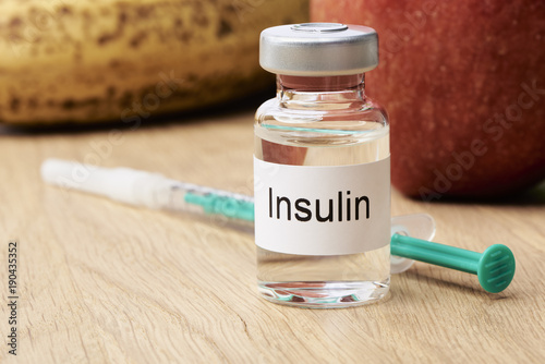 Fotografía Diabetes - Eine Ampulle mit Insulin steht auf einem Tisch und daneben liegt eine Spritze