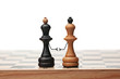 A pair of businessmans reconciles and shakes hands at a meeting. Made from chess kings