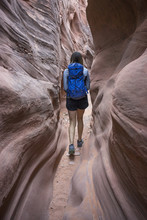 Rear View Of Carefree Female Hiker With Backpack Walking Amidst Canyons