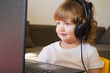 © Angelina - little child with headphones playing computer