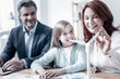 © zinkevych - Confident future. Selective focus on a model of wind turbine standing on a table while a joyful family chatting about alternative energy generation in the background.