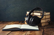 © Alex - Books stand with a pile, Headphones, outdoor Diary on a wooden background. The Concept of Audio Books and Audio Education