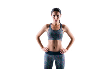 Poster - Front view portrait of serious concentrated beautiful concentrated strict serious fitness trainer wearing tight sportive outfit, she puts her hands on hips, isolated on white background