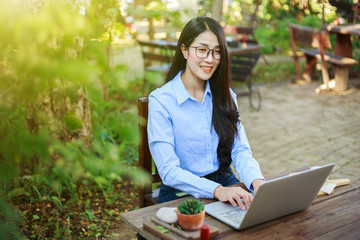 Sticker - young woman using laptop and drinking coffee in garden