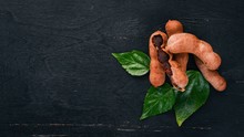 Tamarind. Tropical Fruits. On A Wooden Background. Top View. Copy Space.