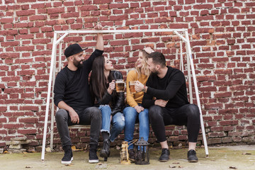 group of young people sitting on the bench talking and having fun, lifestyle concept