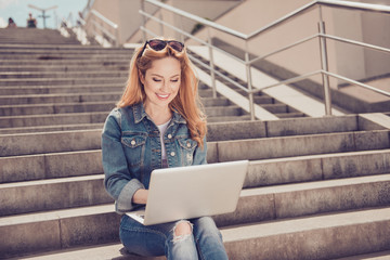 People lifestyle leisure concept. Portrait of cheerful relaxed inspiring beautiful woman casual stylish jacket holding netbook on knees sitting on stone street stairs