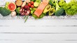 Healthy food. Fish salmon, avocado, broccoli, fresh vegetables, nuts and fruits. On a white wooden background. Top view. Copy space.
