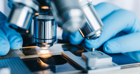 Wall Mural - close-up shot of microscope with metal lens at laboratory.
