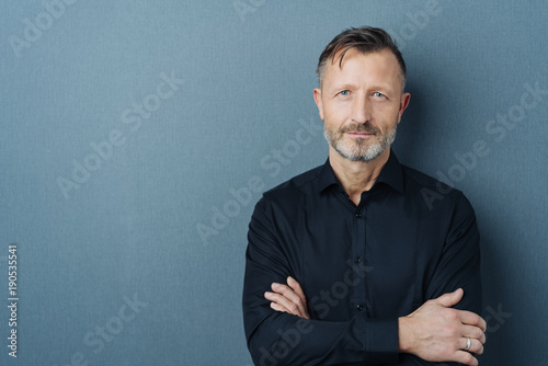 Poster Serious middle-aged man with folded arms