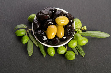 Poster - Black and green  olives  mixed in the  porcelain bowl on gray stone