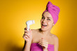 © mnelen.com - happy woman with a towel on her head after a shower holds a brush for deep cleansing of the skin of the face