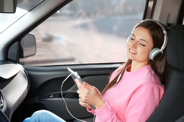 Poster - Woman listening to audiobook through headphones in car