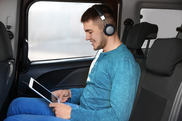 Poster - Man listening to audiobook through headphones in car