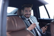 © ASDF - Businessman drinking coffee in car with phone in hand