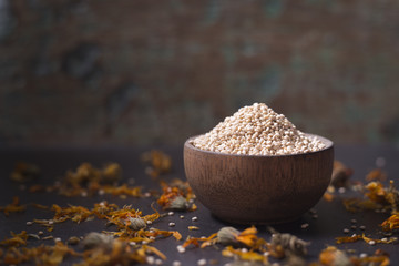 Wall Mural - Quinoa grains in wooden bowl on black background