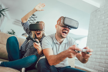 Wall Mural - Happy friends playing video games with virtual reality glasses - Young people having fun with new technology console online