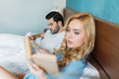 © LIGHTFIELD STUDIOS - couple reading books in bed in hotel room