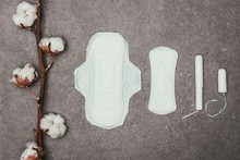 Top View Of Arrangement Of Cotton Twig, Menstrual Pads And Tampons On Grey Surface