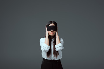 Wall Mural - young blindfolded woman closing ears isolated on grey