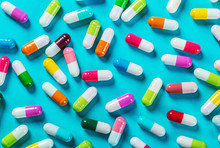 Different Color Pills On Blue Background. Drugs And Medicines