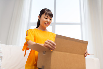 happy asian young woman with parcel box at home